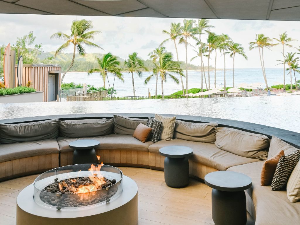outdoor seating area with a fireplace overlooking the ocean from turtle bay