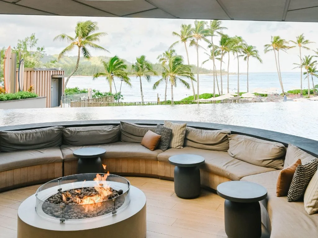 outdoor seating area with a fireplace overlooking the ocean from turtle bay
