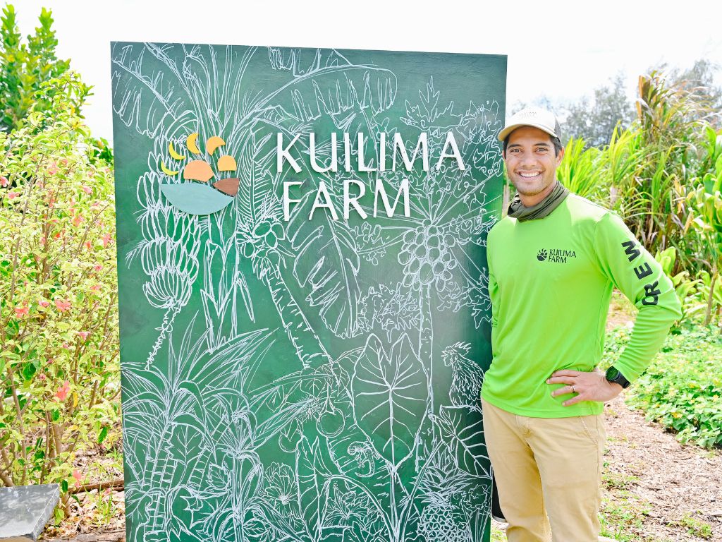 man standing by the kuilima farm sign near turtle bay blog resort