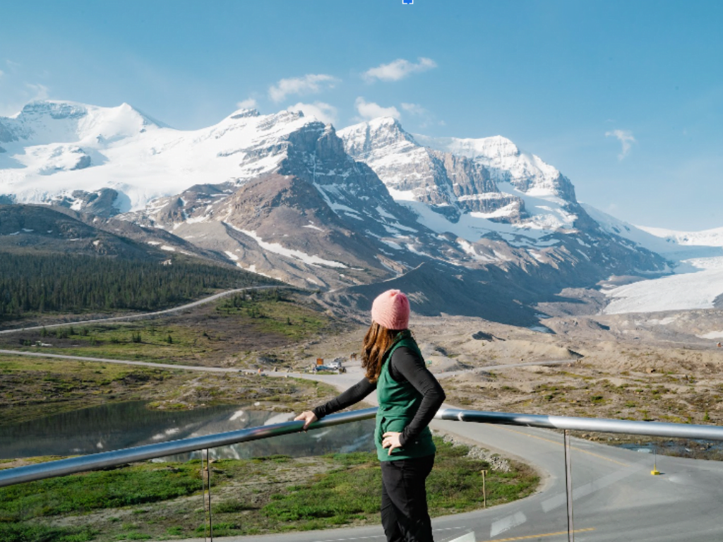woman overlooks the rocky mountains from the glacier view lodge