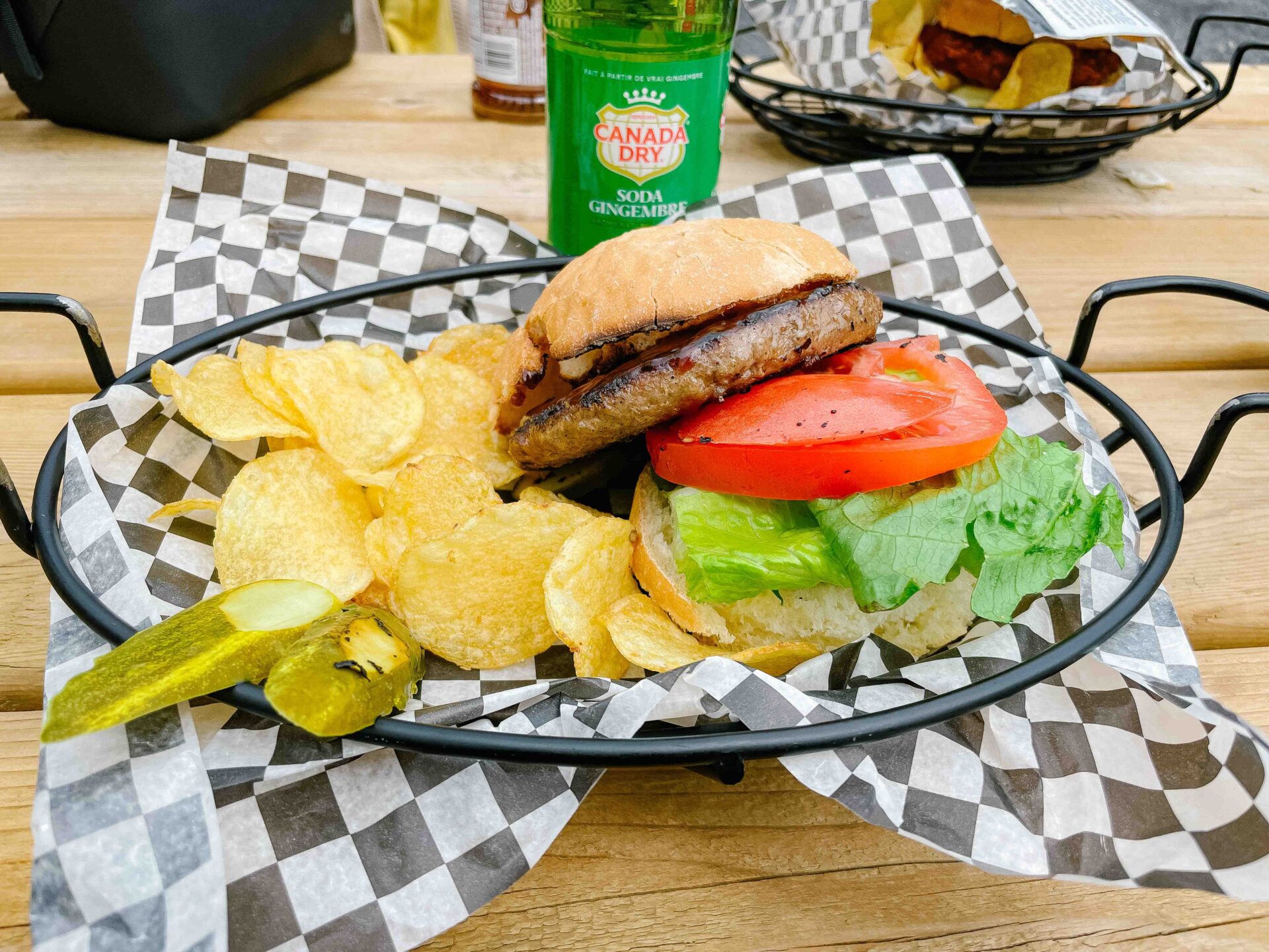 burger with chips a pickle and a bottle of gingerale