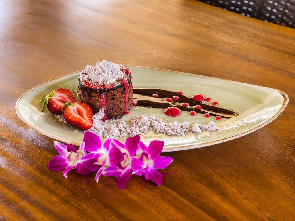 chocolate cake sitting on a plate adorned with strawberries and chocolate sauce