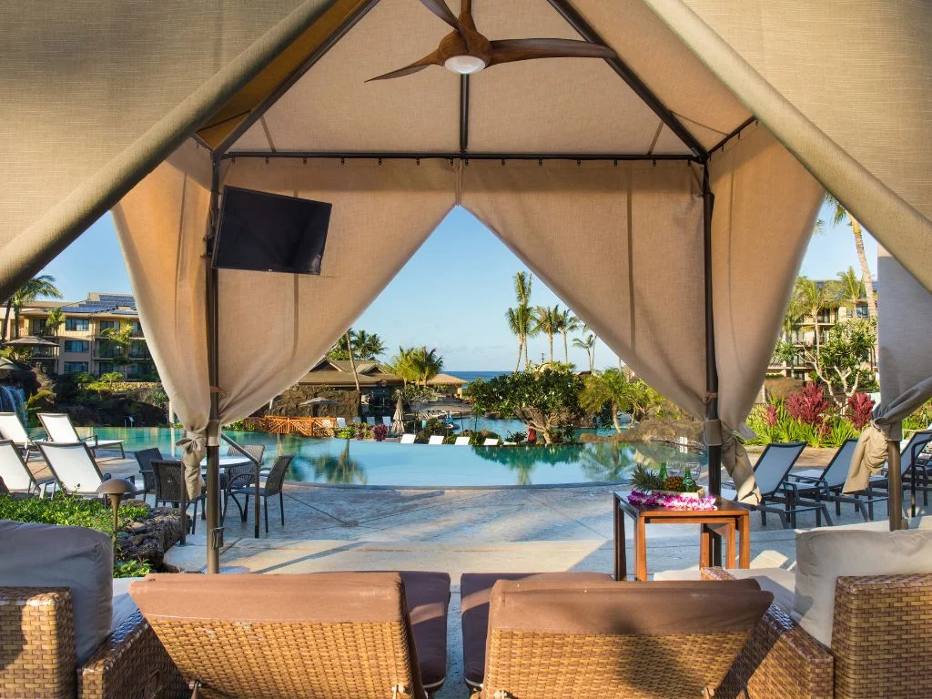 view from sitting under a pool cabana overlooking the pool at the koloa landing resort
