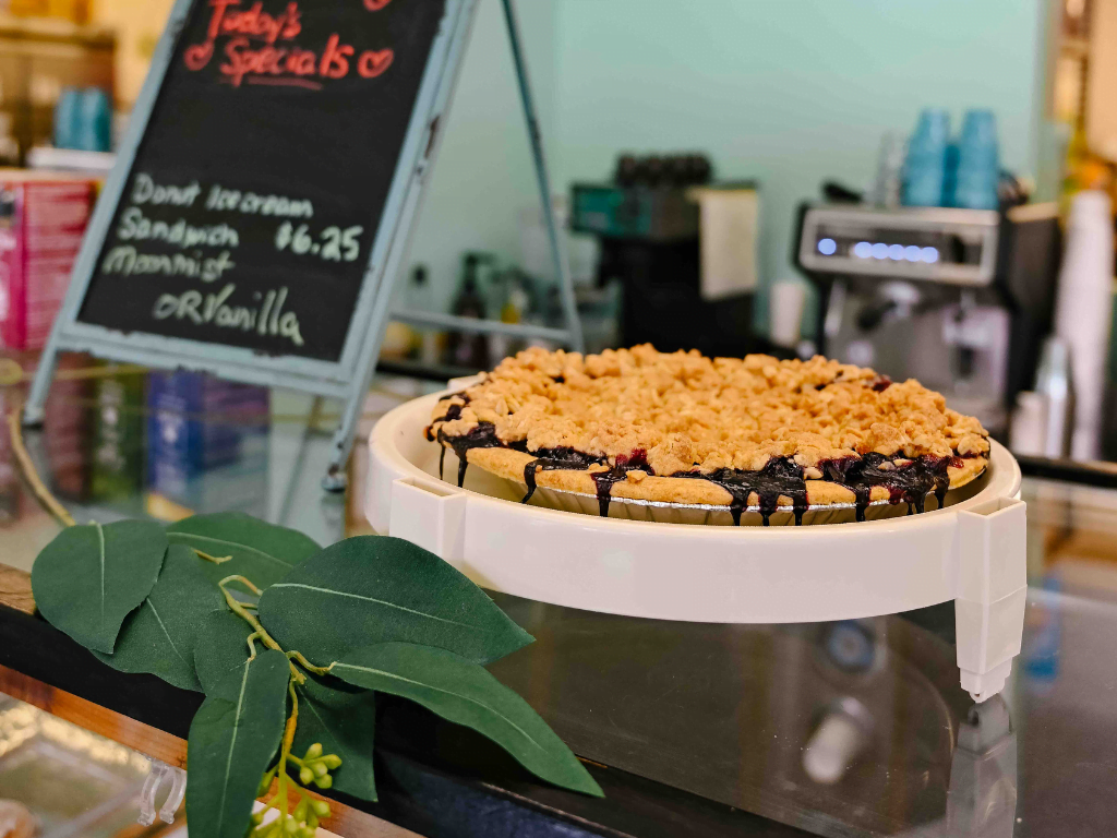 close up of a fruit crumble pie sitting on a counter of a cafe