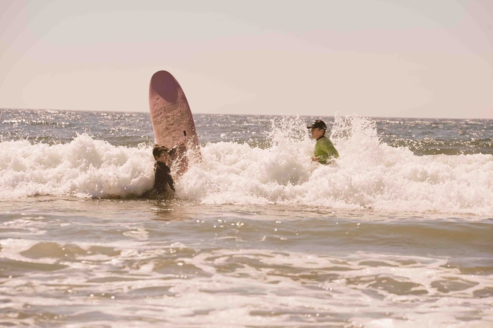 a child learning to surf on the eastern shore of nova scotia with their instructor