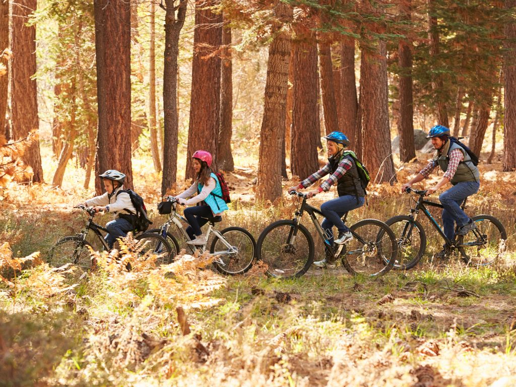 family riding their bikes through the forest on a mountain bike tour in squamish
