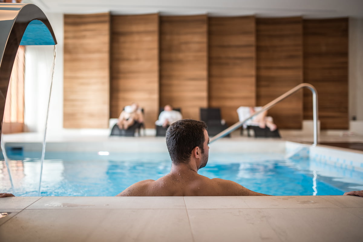 a person sitting in a pool inside the aroma spa at Hôtel de Glace