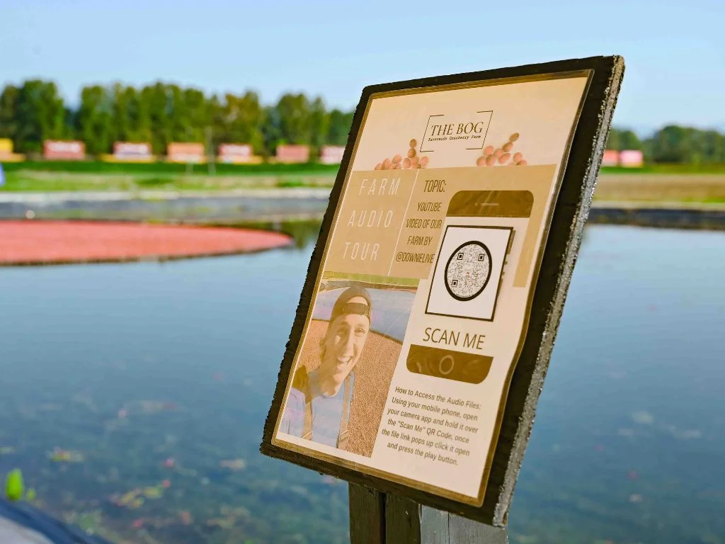 a sign showing how to access the farm audio tour at Cranberry Plunge Langley