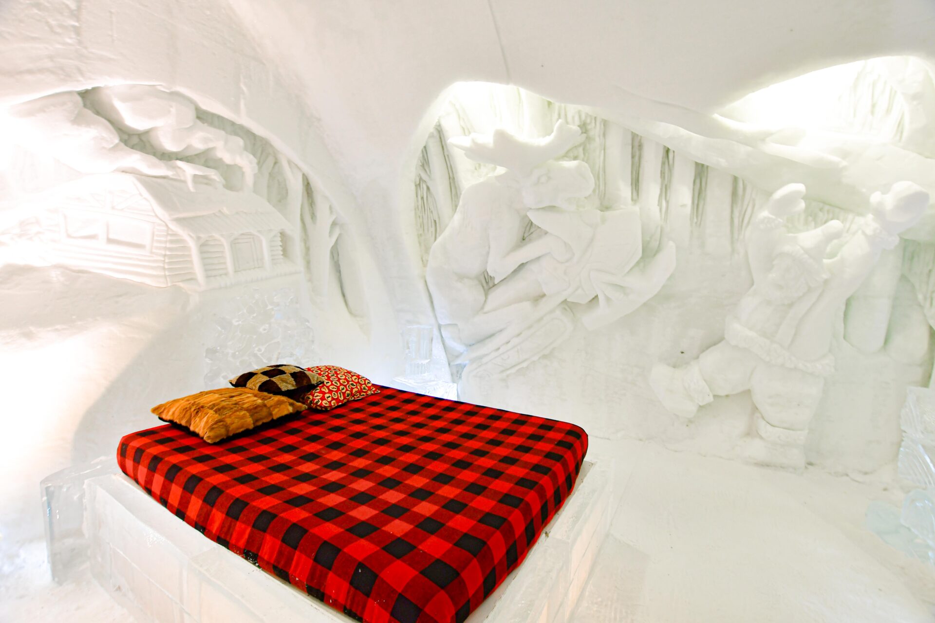 a themed room at Hôtel de Glace that depicts a log cabin, a moose riding a snowmobile and a nordic person
