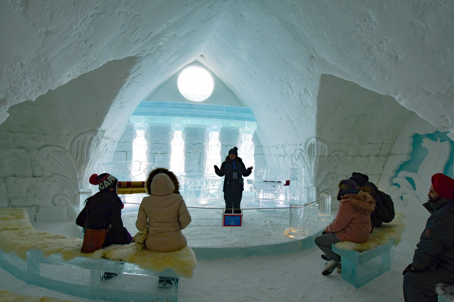a tour guide stands in front of a group of people inside one of the areas of the Hôtel de Glace