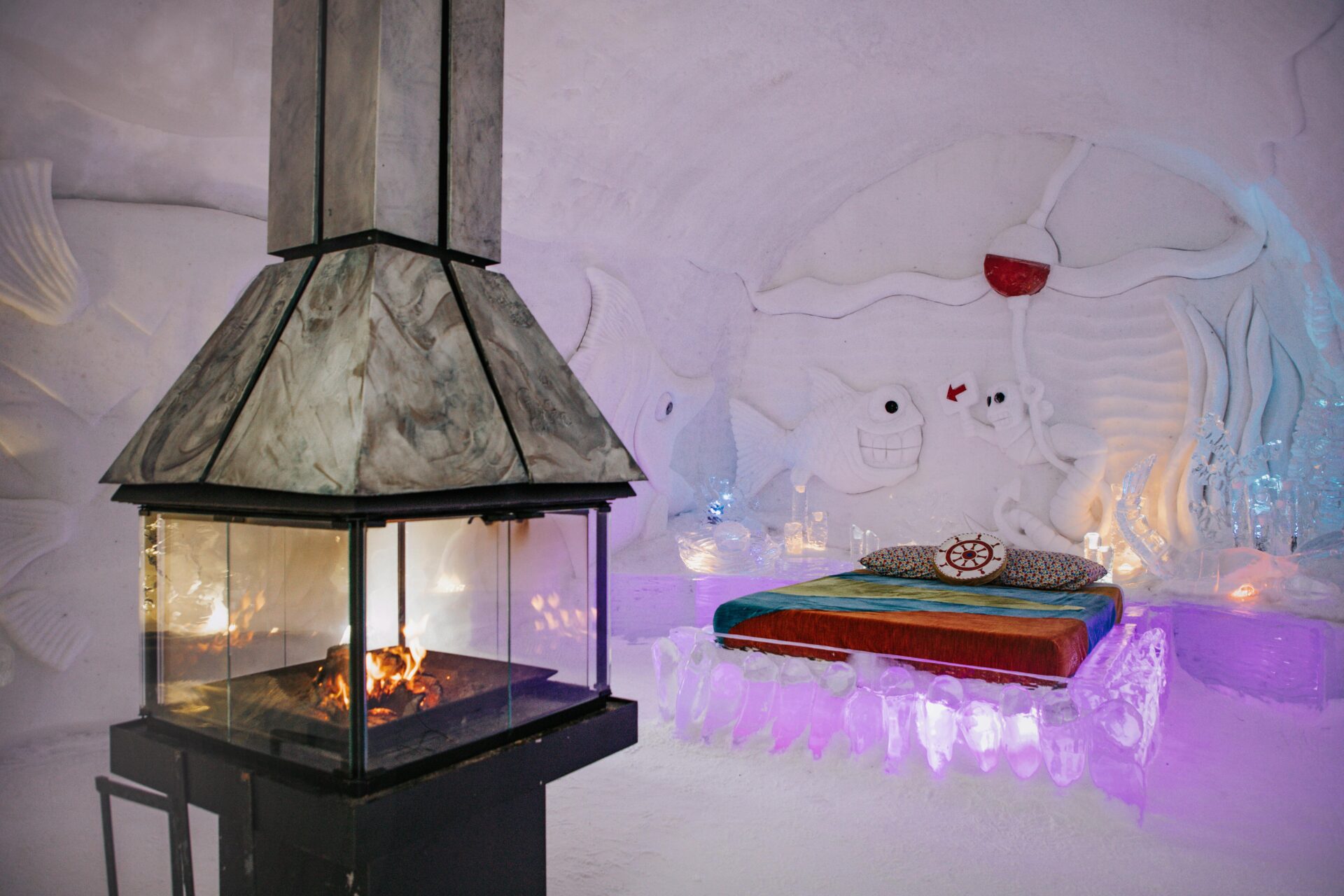 inside the premium suite at Hôtel de Glace, a king size bed and fireplace is in the room