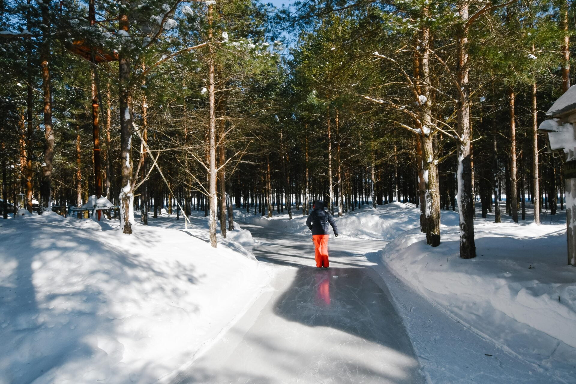 a woman stands in a Y in the trail at the lac des loups skating adventure