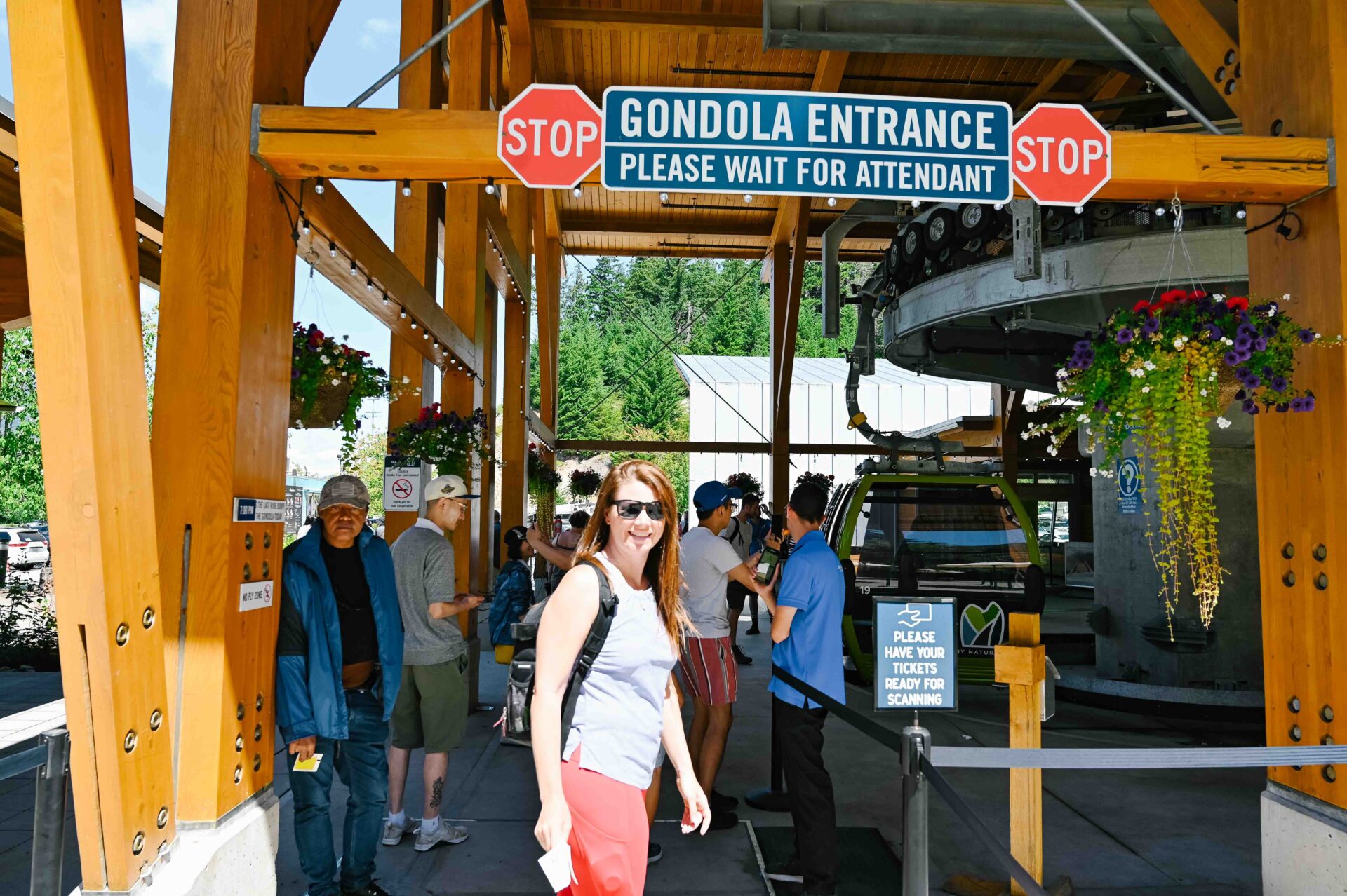 woman stands smiling at the camera at the gondola entrance
