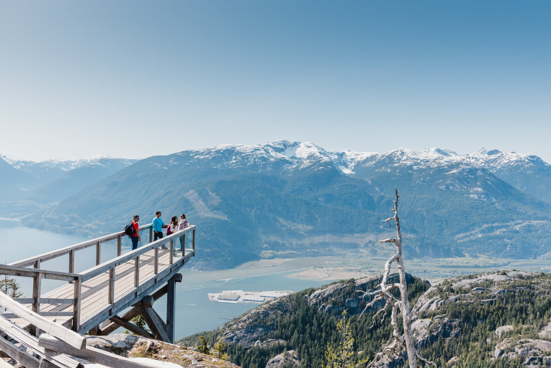 4 people standing on a lookout platform above squamish