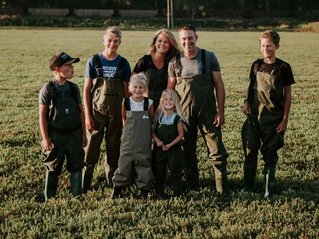 dewit family standing in a cranberry bog at their farm