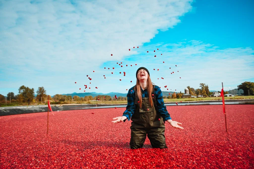 woman doing the cranberry plunge langley and throwing cranberries in the air