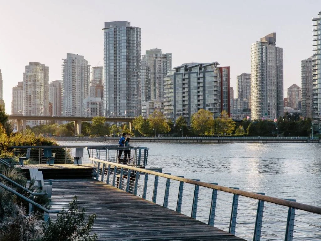 two people standing on the seawall in false creek