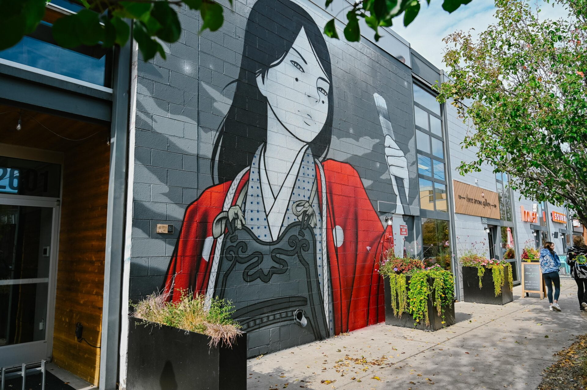 mural of a woman wearing red and holding a paintbrush
