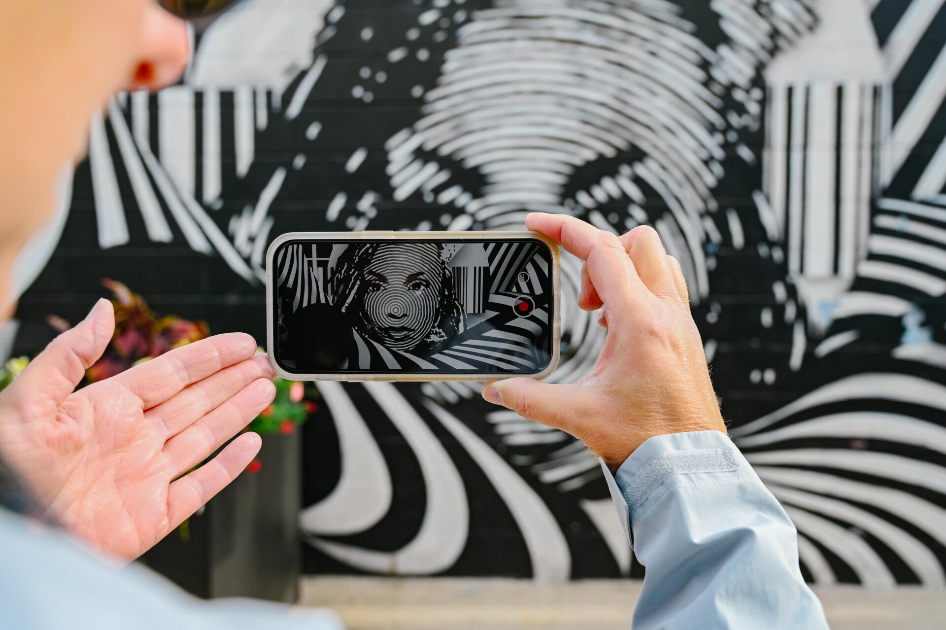 a woman showing an interactive video of a mural on her phone, while on the denver graffiti tour