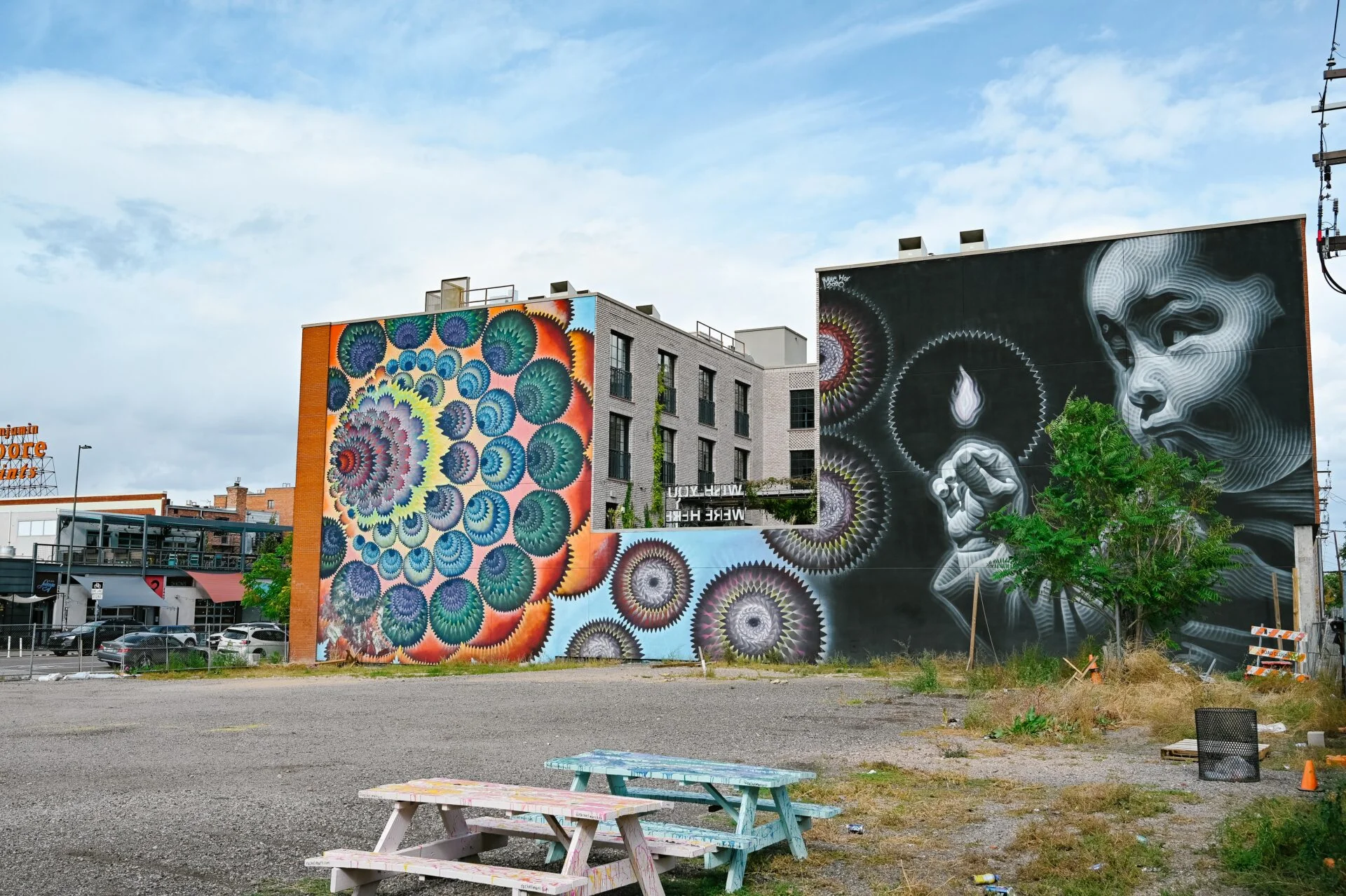 large mural depicting a mosiac of colours on one side and a small child holding a flame on the other, seen on the denver graffiti tour