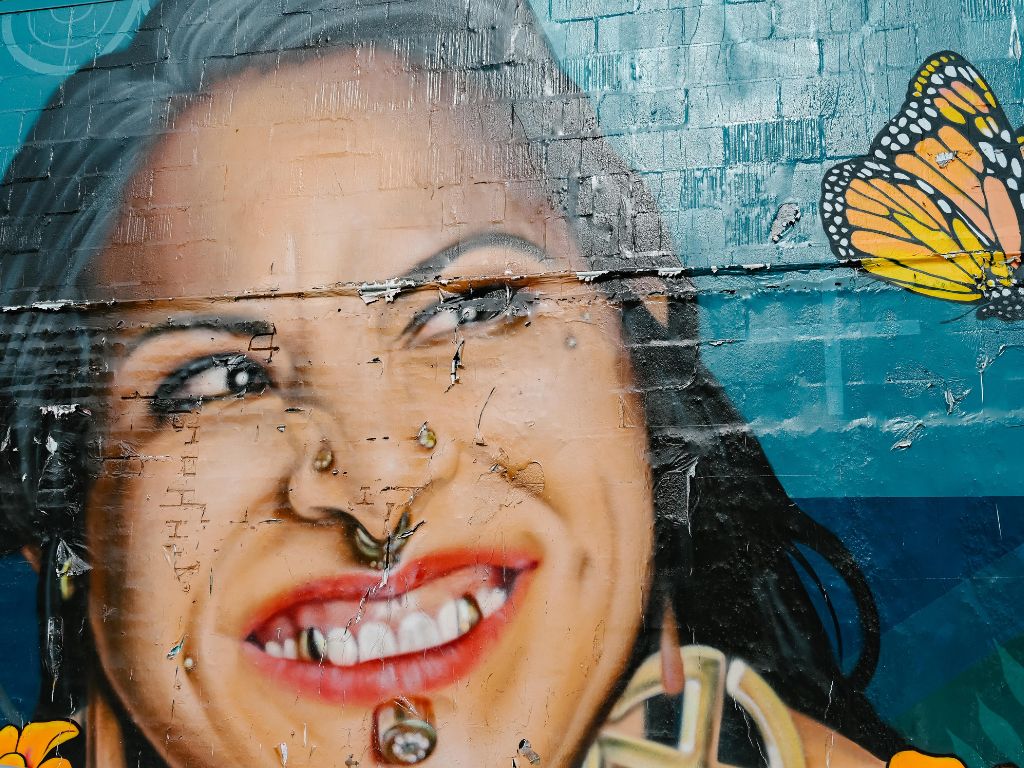 close up realistic portrait mural of a woman looking at a butterfly
