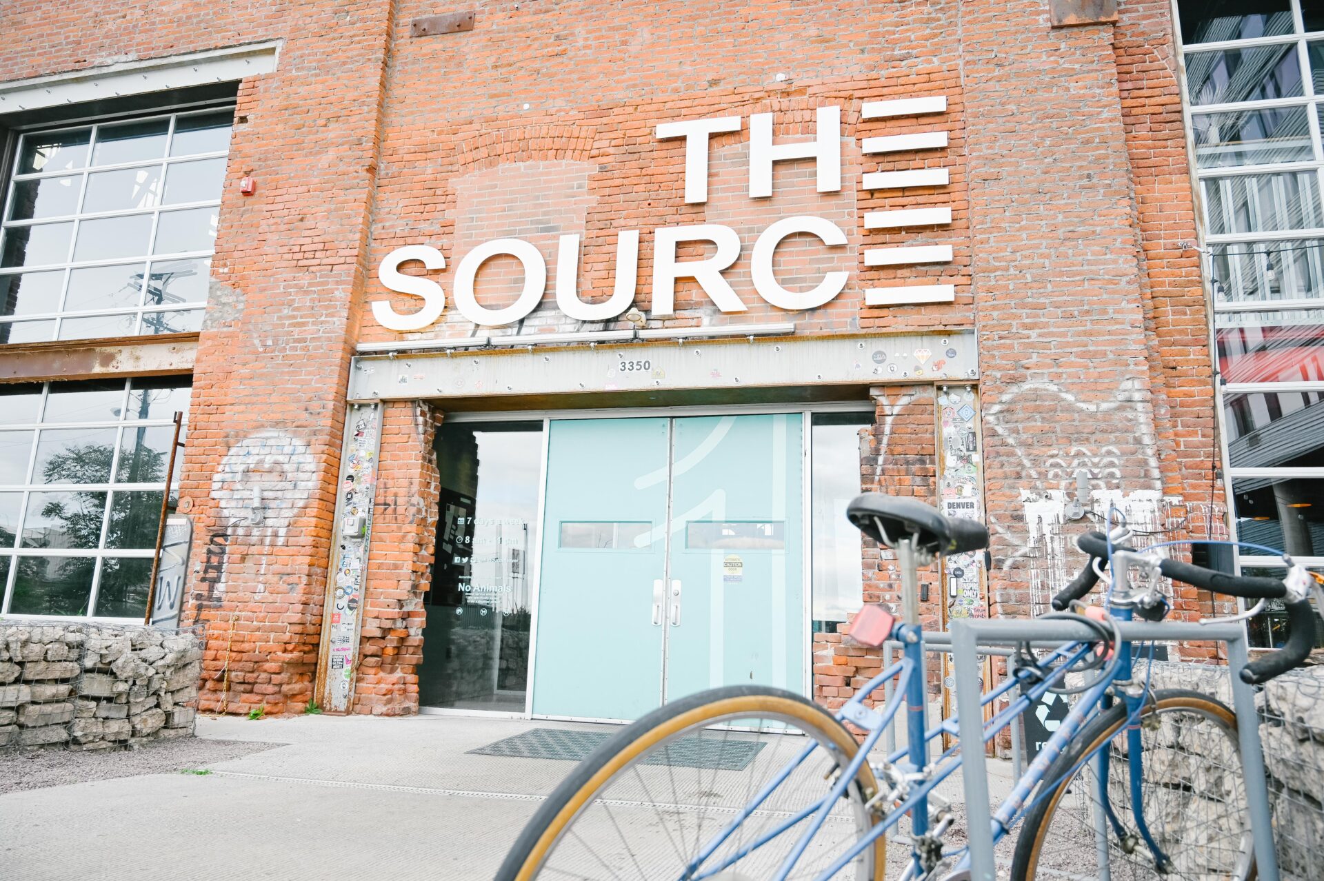 close up view of the front door of the market hall at the source, a bike sits locked in a bike rack