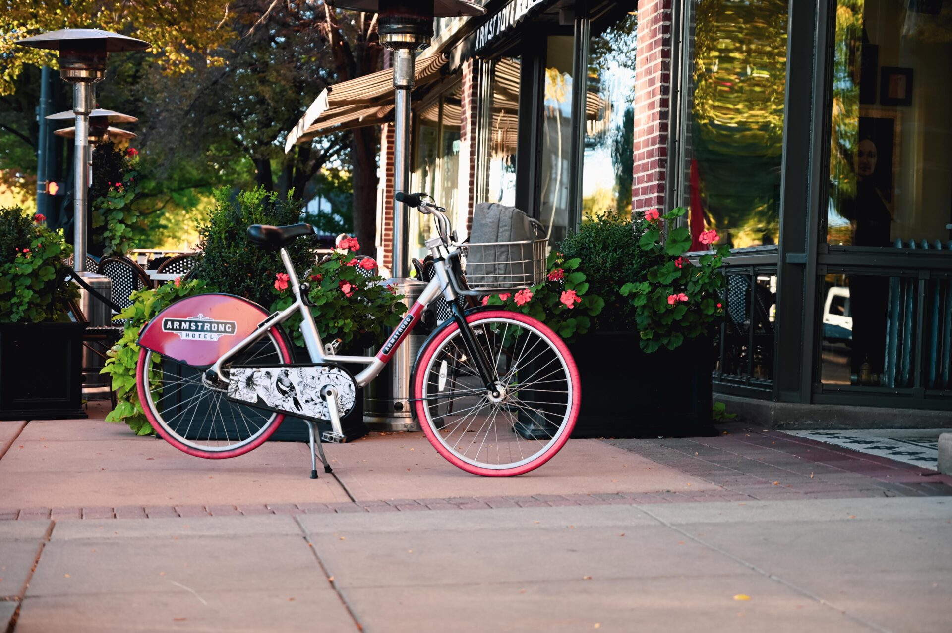one of the armstrong hotel fort collins pedal bikes parked outside the front entrance of the hotel