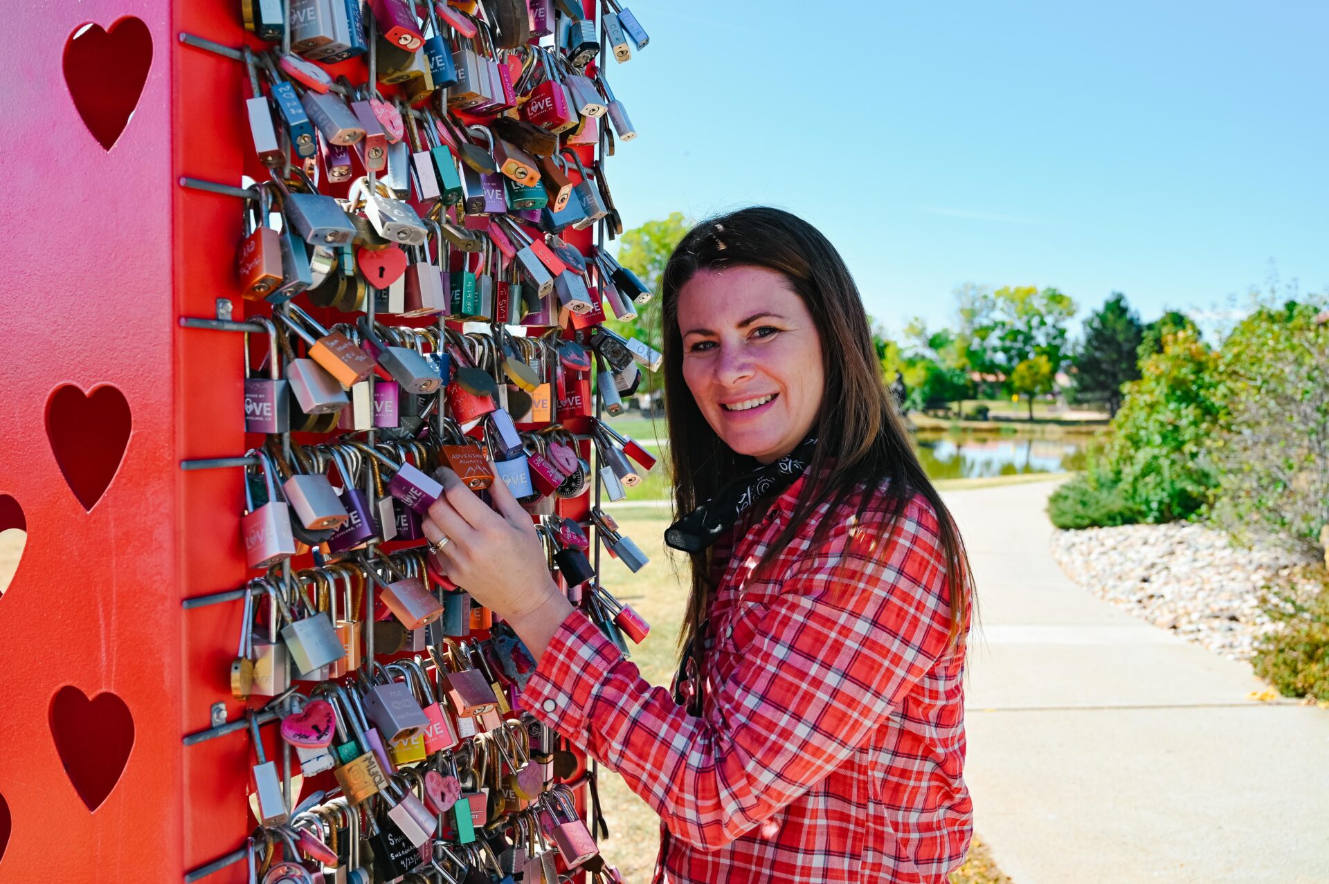 woman stands beside the love lock structure at the loveland visitors centre on her northern colorado road trip