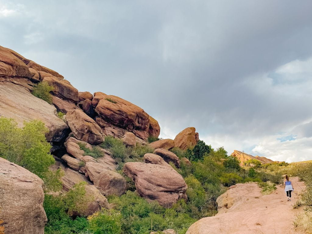 woman hikes at red rocks park and amphitheater in colorado