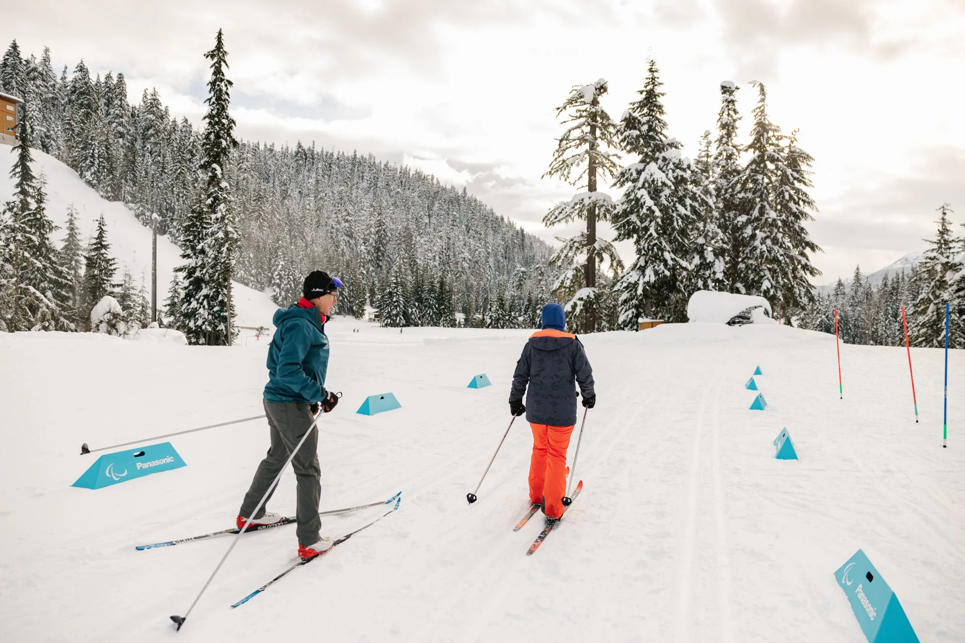 two people are nordic skiing on a biathlon course at the whistler olympic park