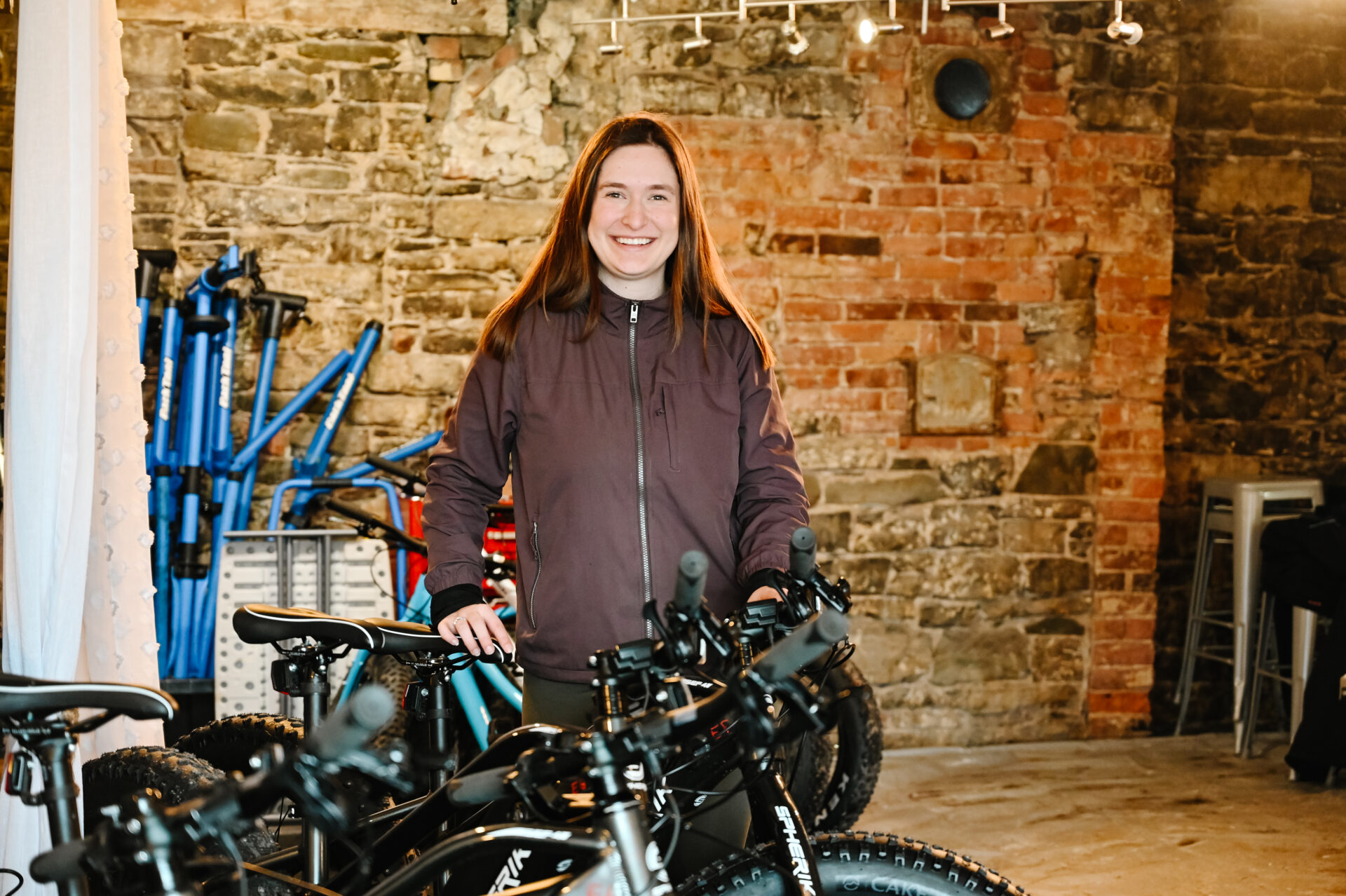 owner of the tuque & bicycle experiences, quebec city bike rental shop, stands by bicycles in her store