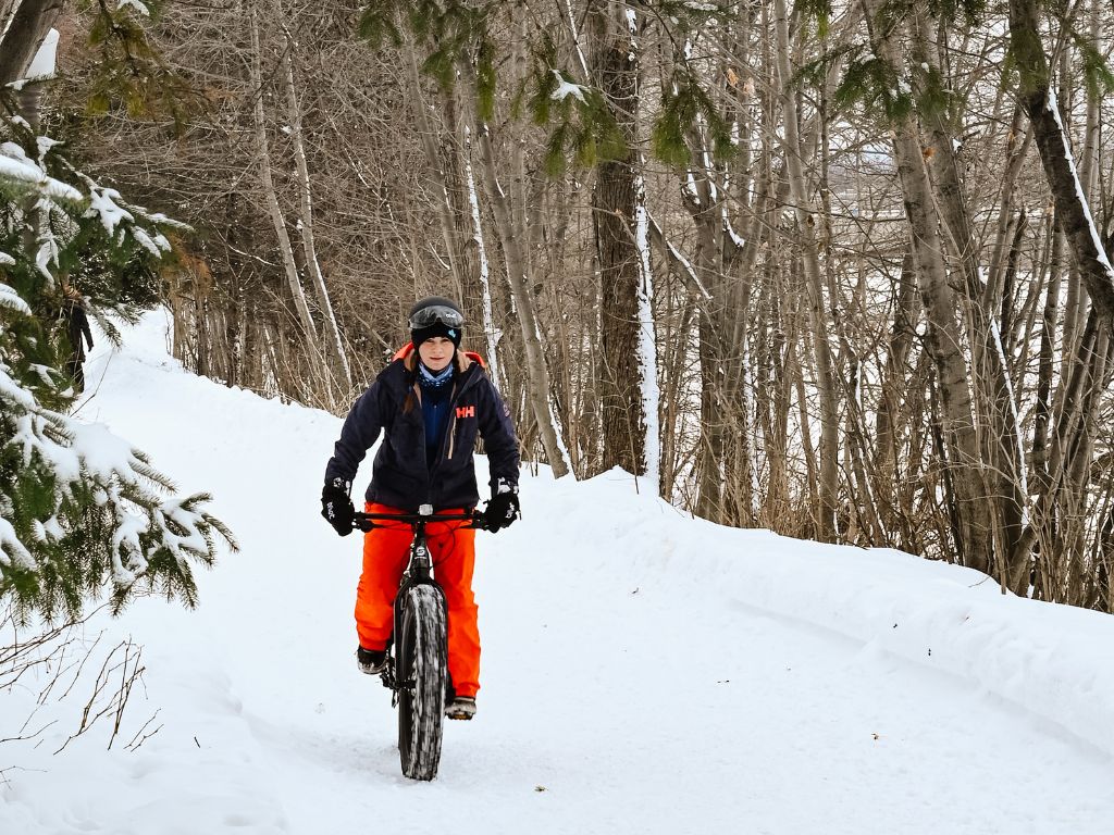 woman riding a fat e-bike on a snowy trail in quebec city
