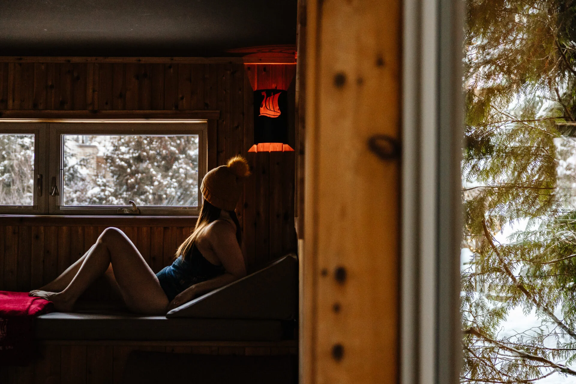a woman wearing a yellow toque relaxes inside a sauna at scandinave spa, one of the things to do in whistler in winter for non-skiers
