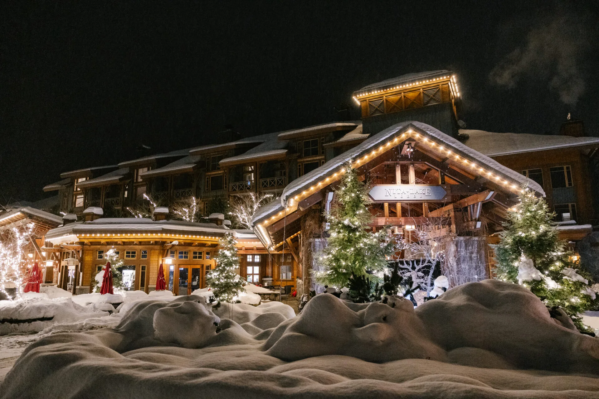 front entrance view of the nita lake lodge in whistler in winter in the early evening