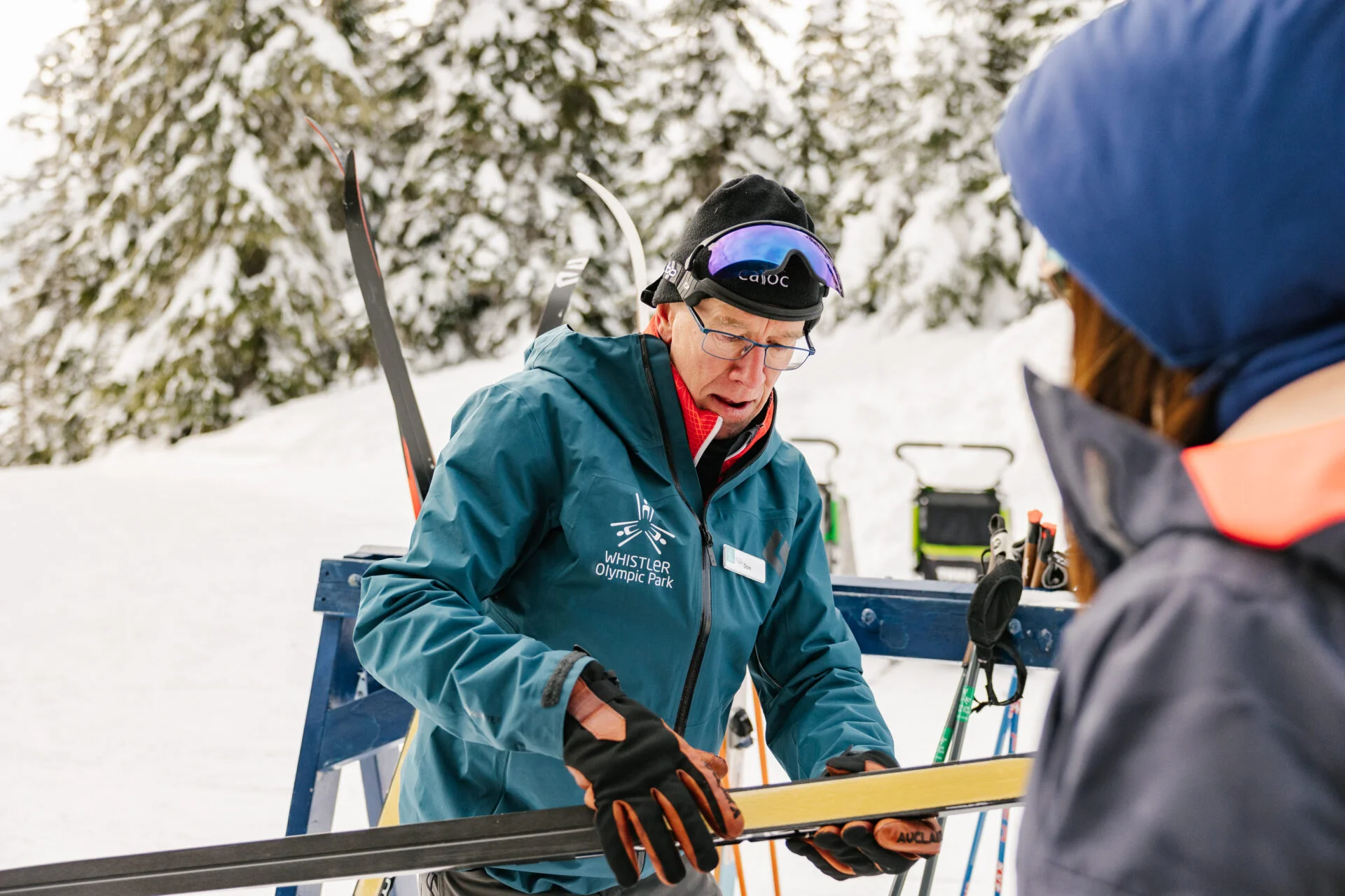 a man holding a cross country ski while explaining the instructions on how to nordic ski