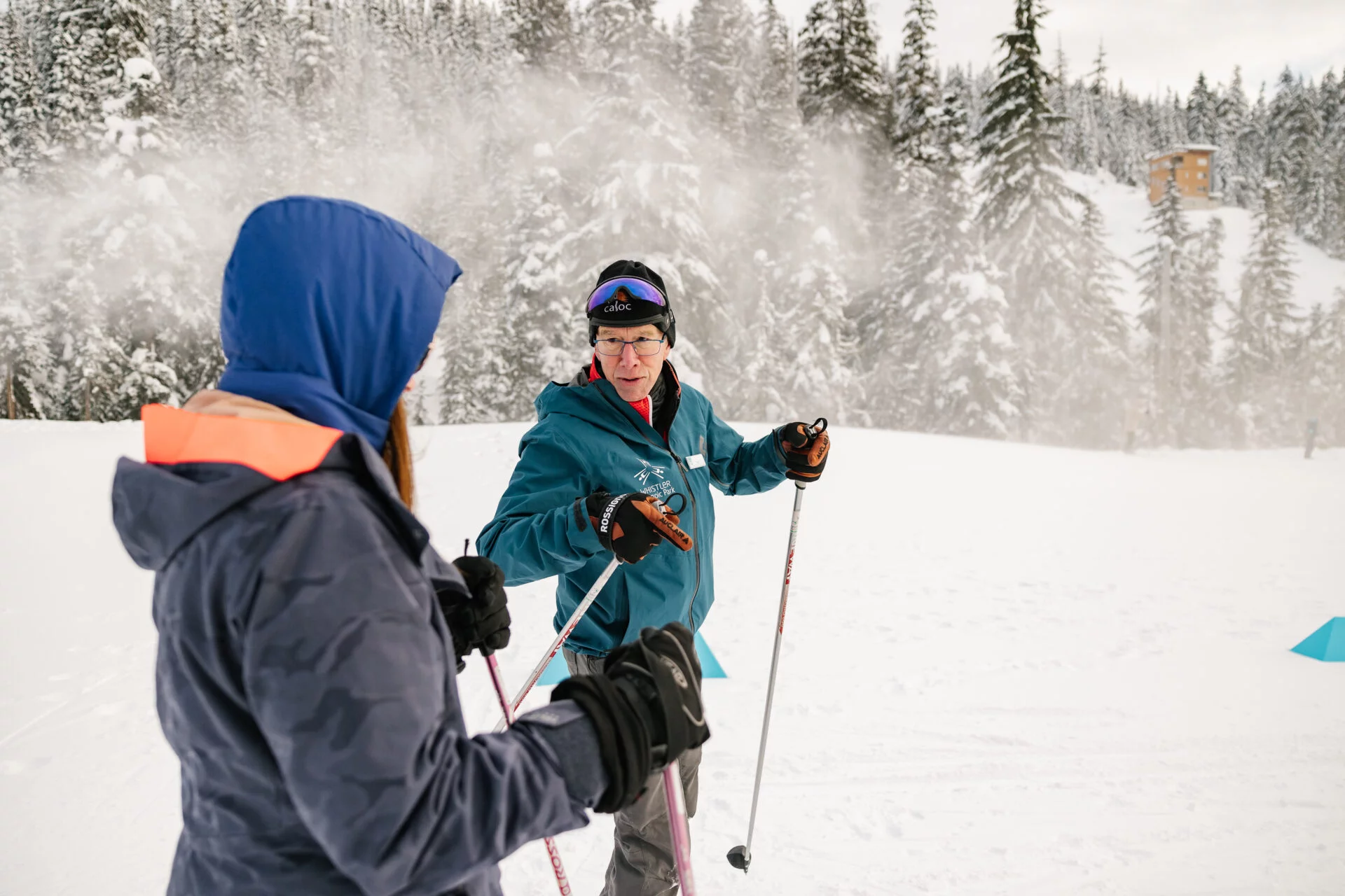 a nordic ski instructor is teaching a person how to cross country ski
