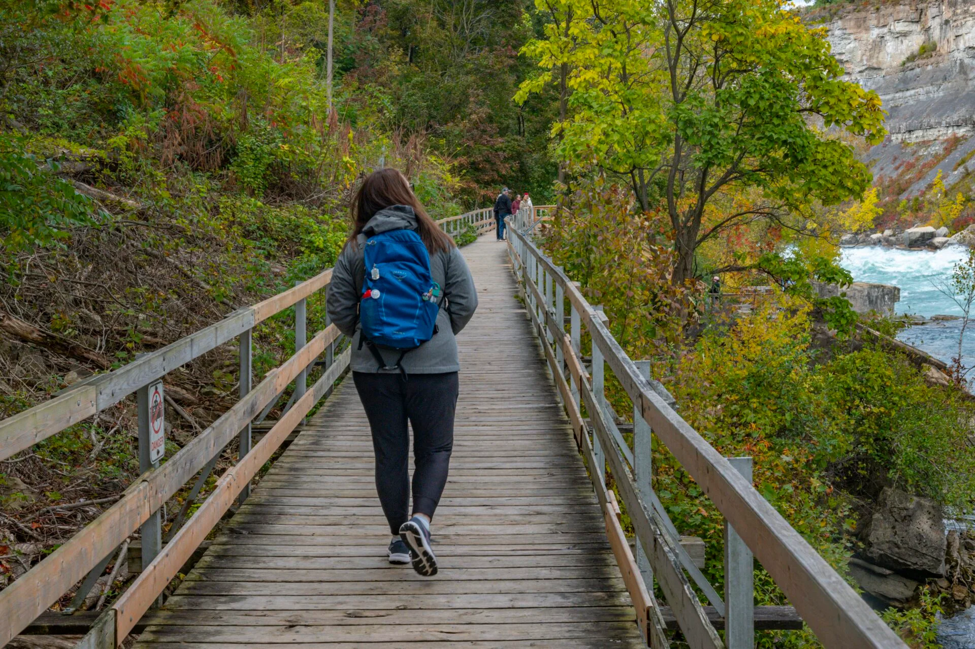 a woman walks along the boardwalk at the white water walk in Niagara Falls in October