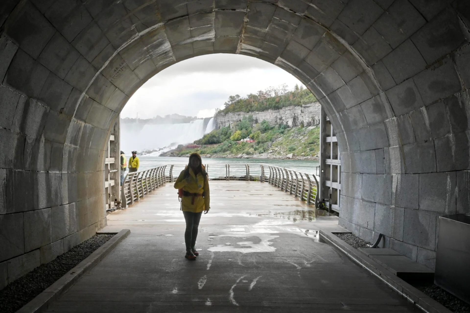 a woman stands at the exit of the tunnel at the niagara parks power station attraction