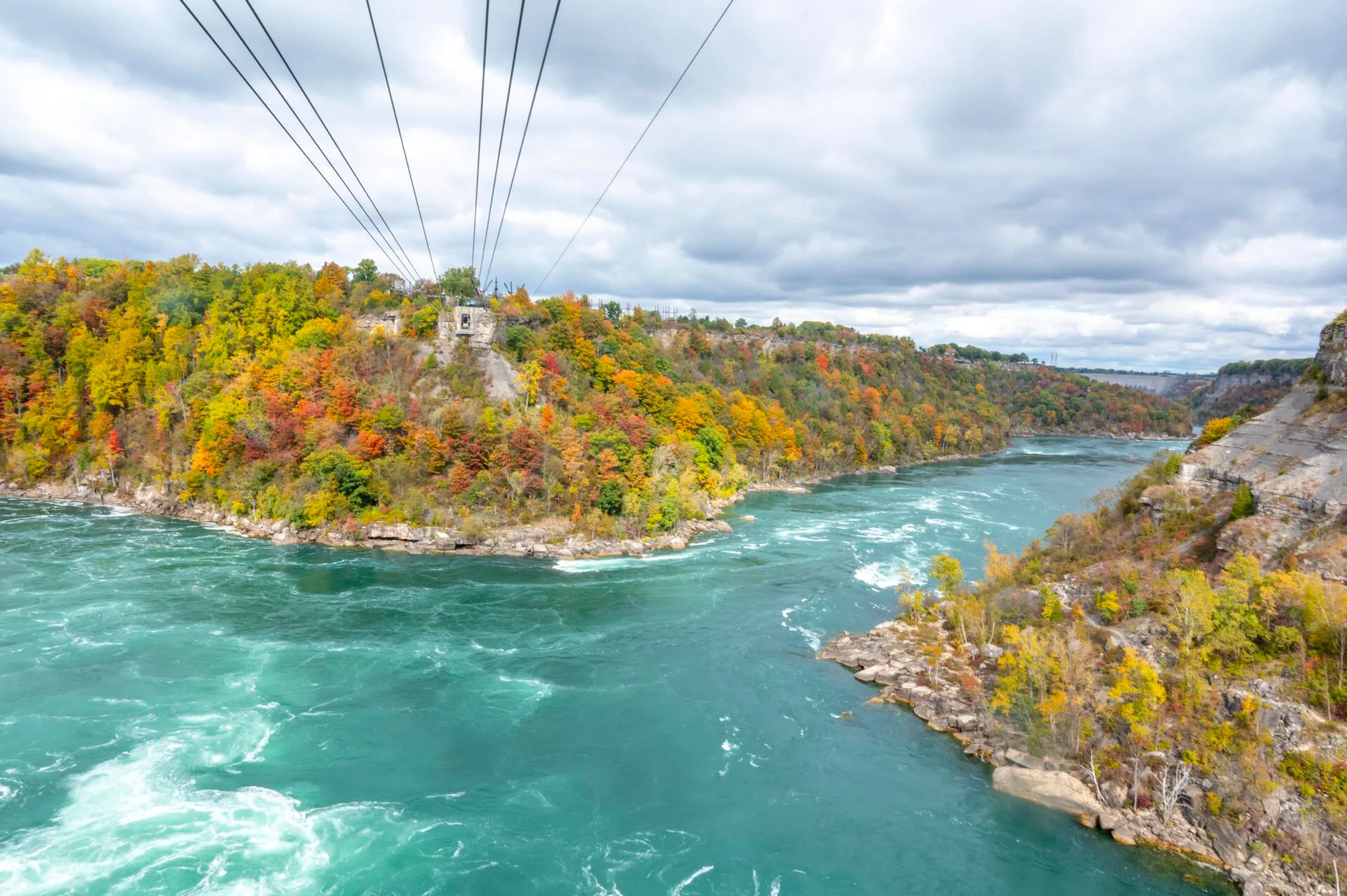 view from the whirlpool aero car in Niagara Falls in October, fall foliage can be seen in the distance
