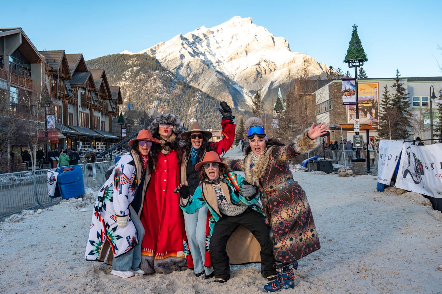 a group of 5 women, smile excitedly at the camera