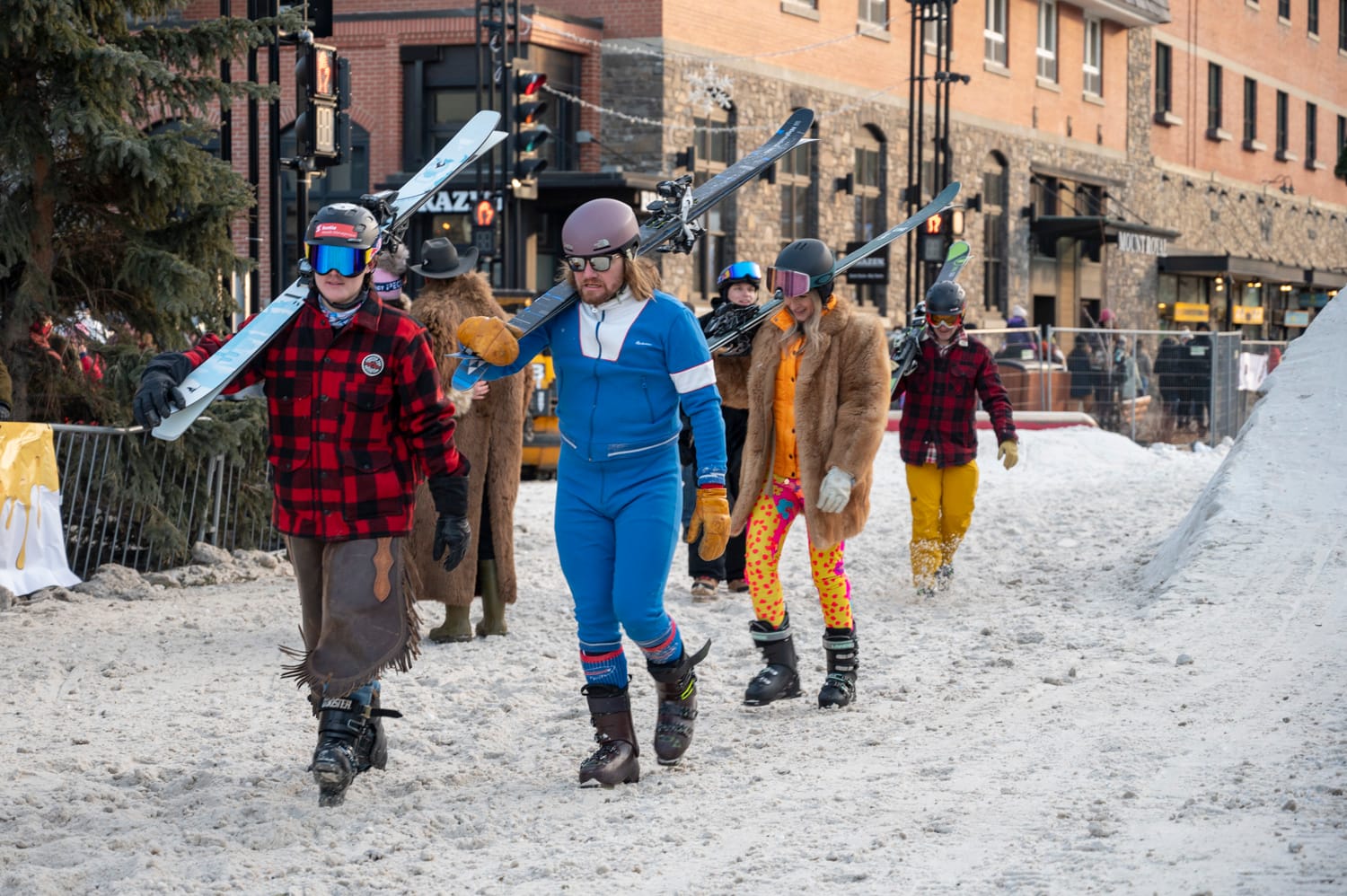 the skijoring sliders all walking and carrying their skis over their shoulders