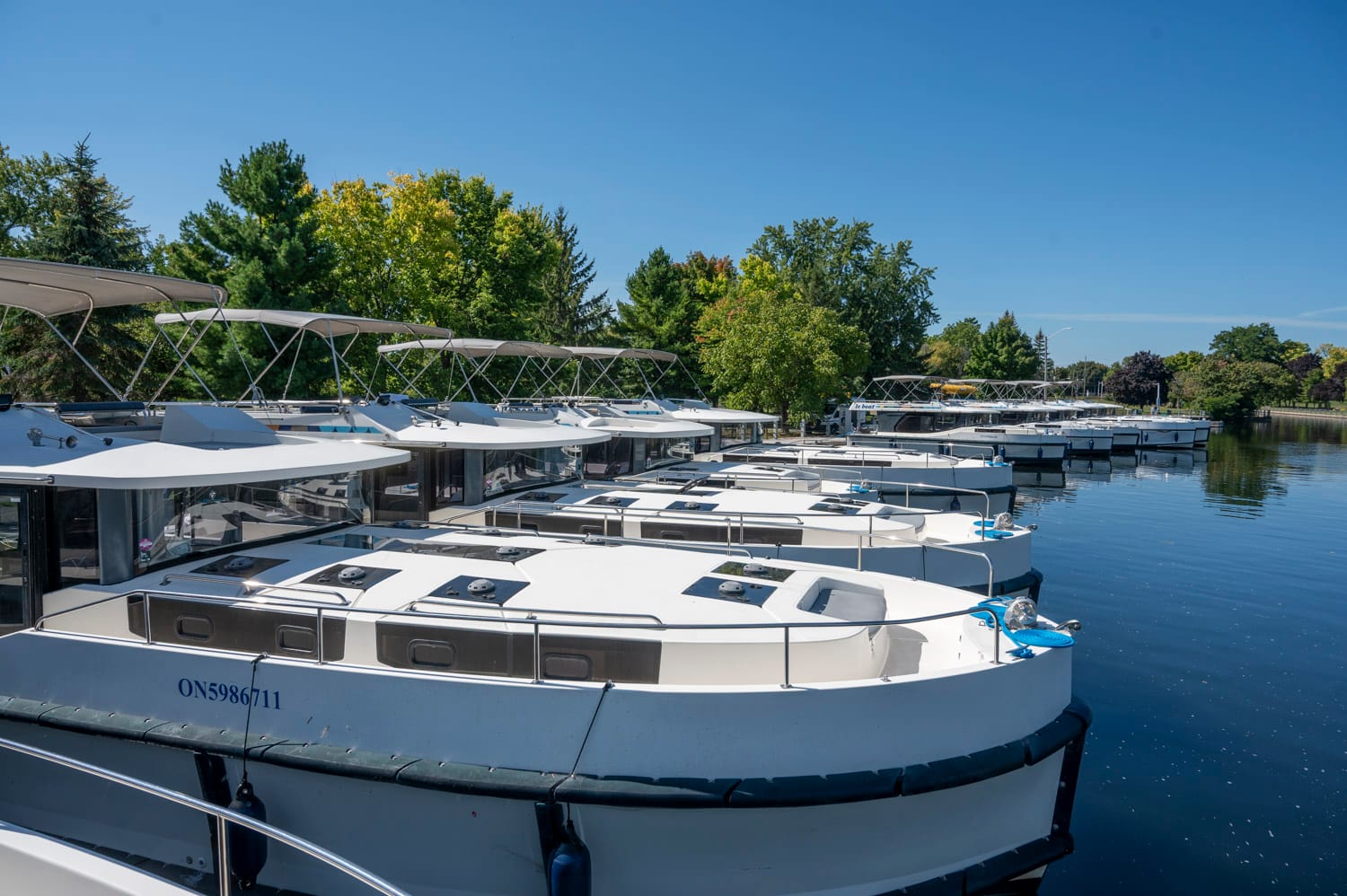 a line up of le boat luxury houseboats sit docked in a line