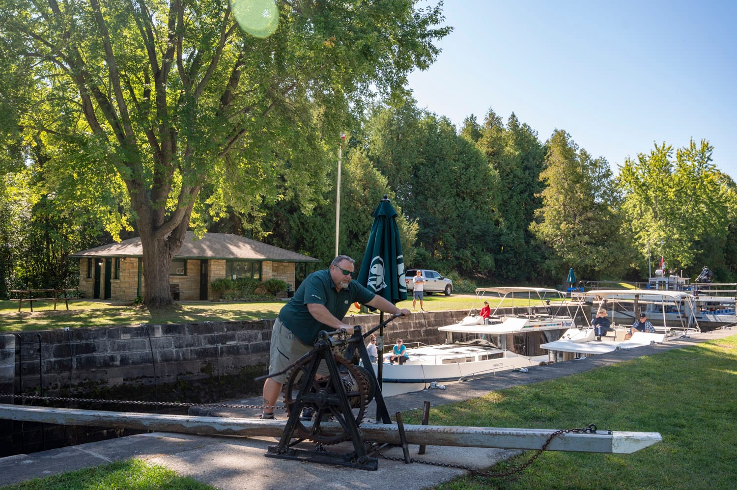 a parks canada lock staff member is cranking the locks, le boat houseboats are in the background