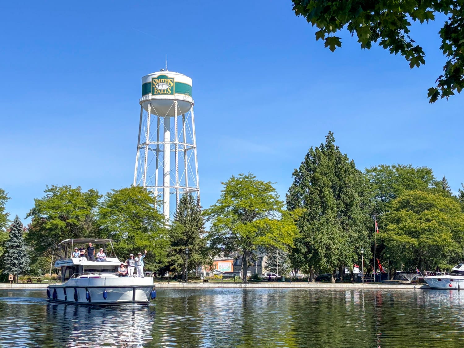a group of women on a le boat houseboat, the smith falls town tower is in the background