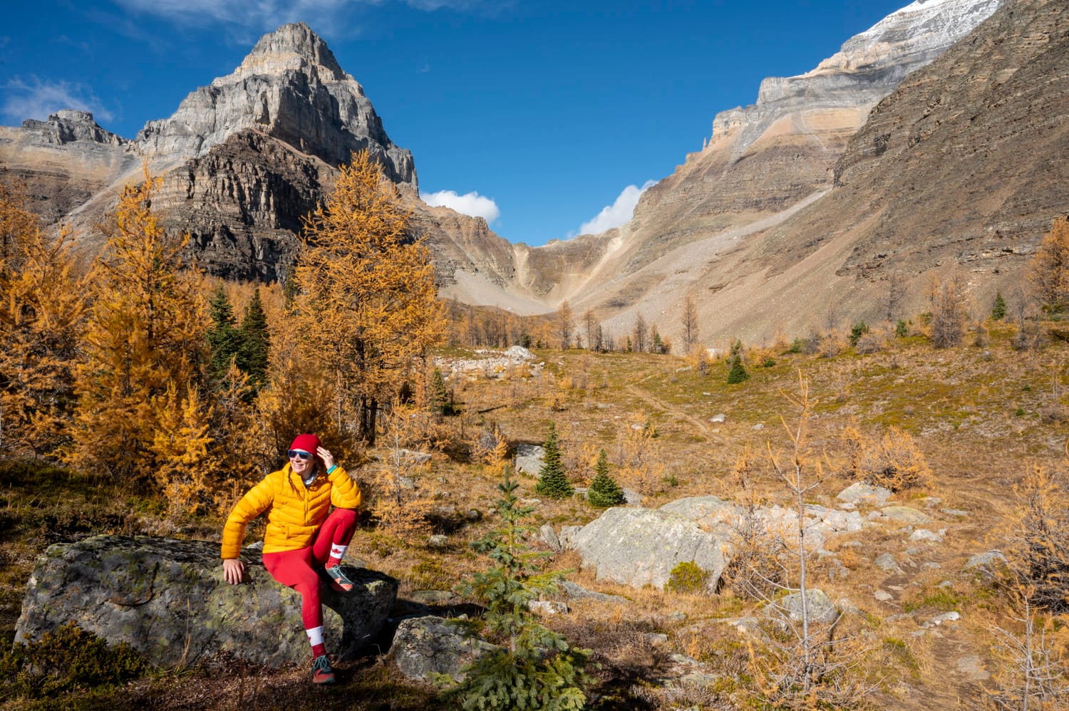 woman wearing yellow and red hiking gear in larch valley in banff alberta