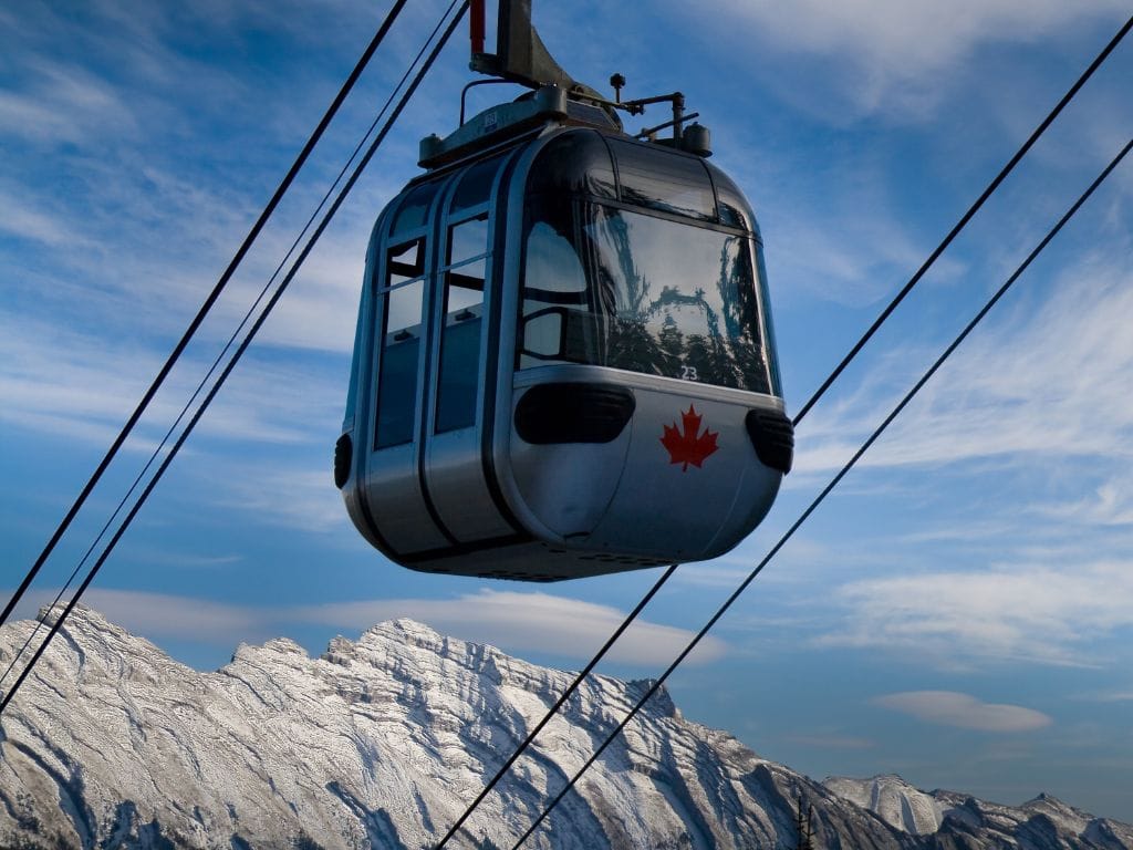 close up of one of the banff gondola cars, mountains can be seen in the background