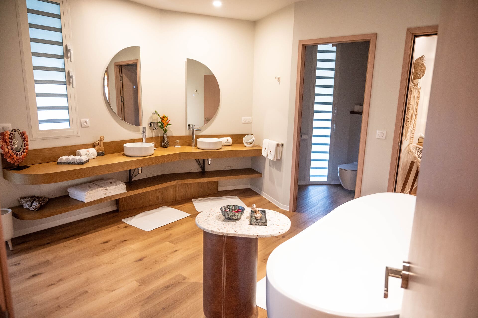 Inside the Apatoa Raiateta Luxury Villas - a big bathroom with a walk-in shower, an oversized soaker tub, dual sinks, and mirrors