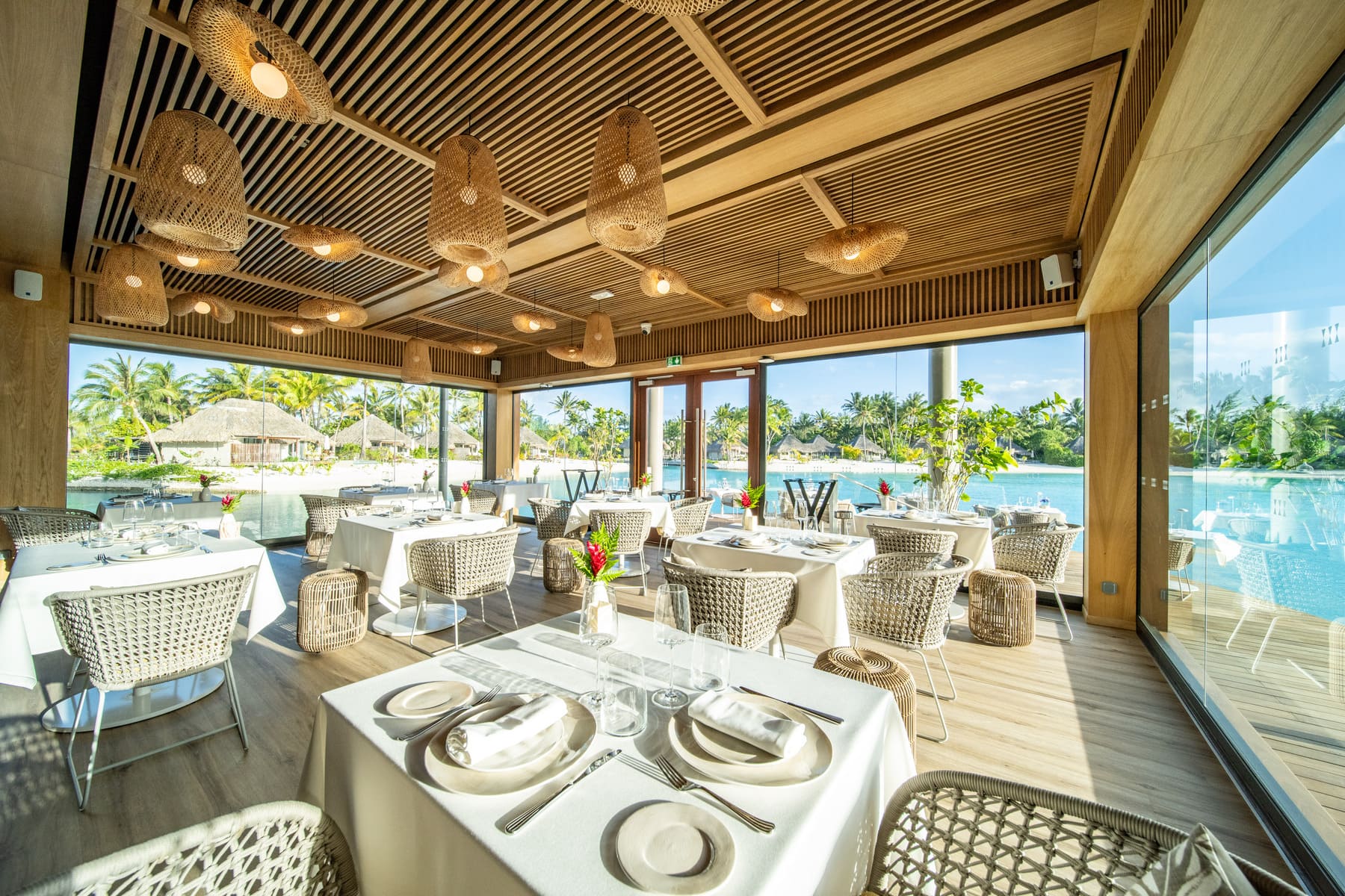 luxury tropical resort restaurant, waterfront dining, Polynesian bungalows, palm trees, turquoise water, fine dining
