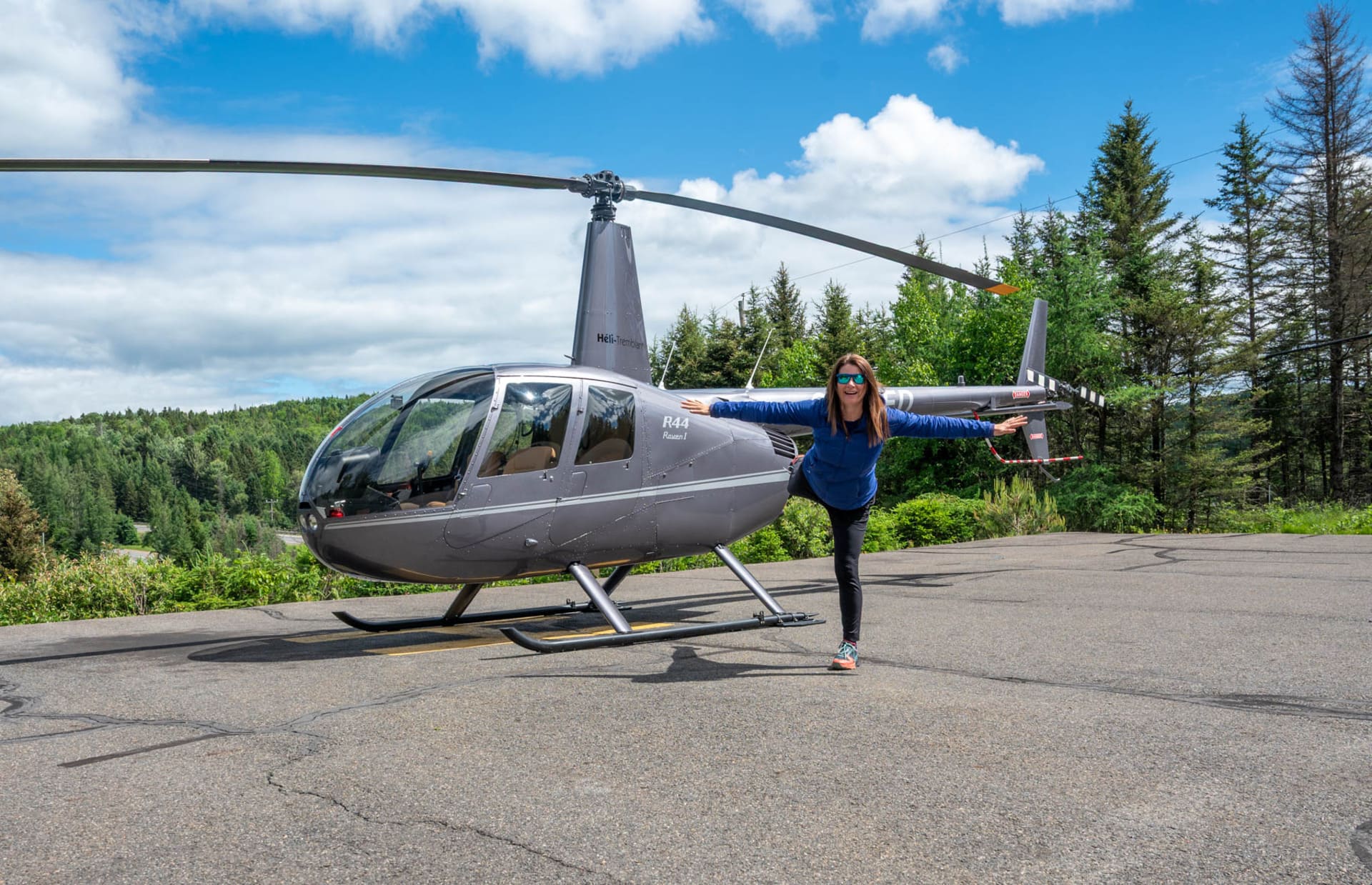 Jami Savage balancing next to a grey Heli-Tremblant helicopter