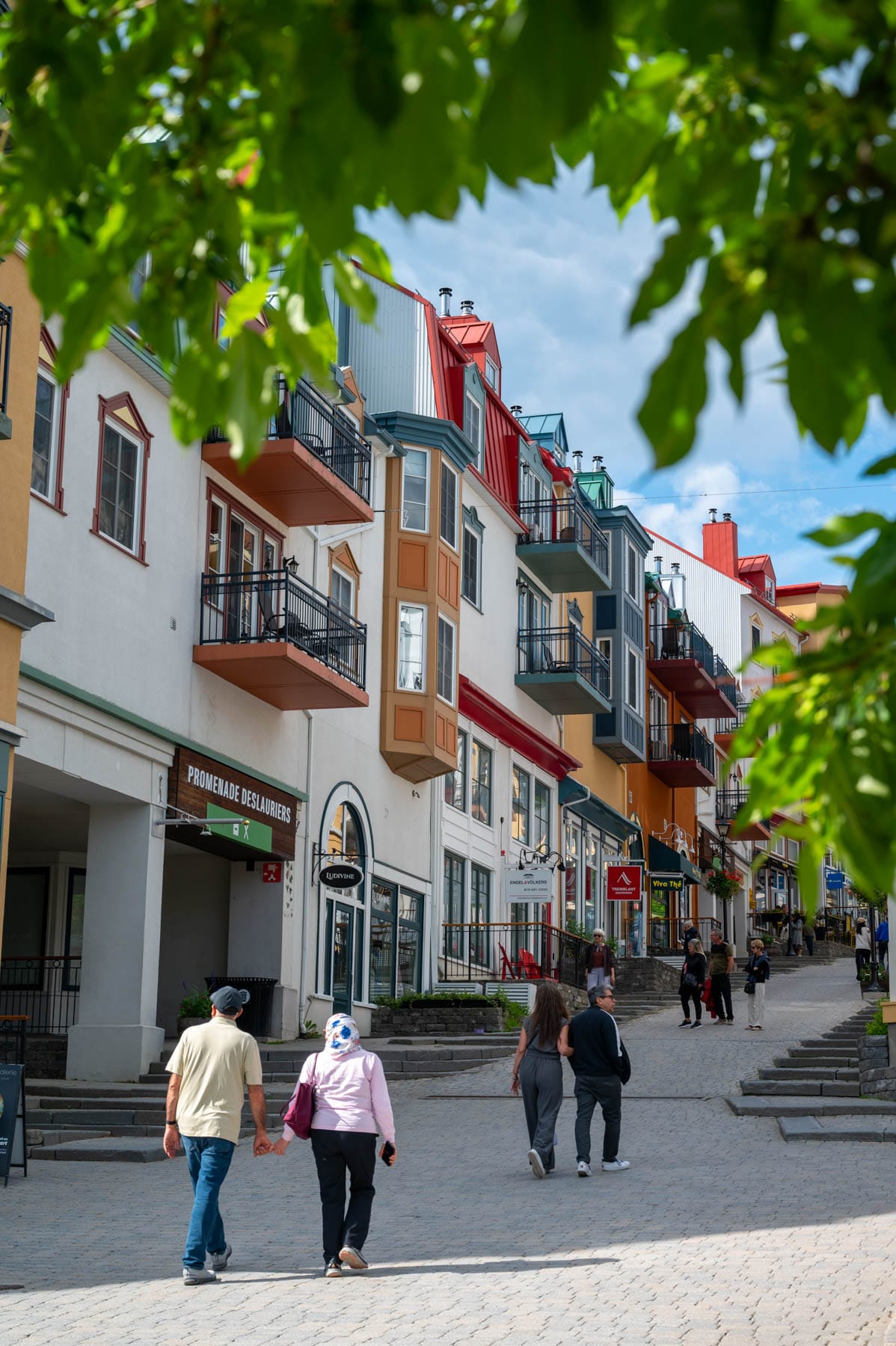 Mont Tremblant village street, colorful buildings, cobblestone road, pedestrian zone, Quebec tourism, vibrant architecture